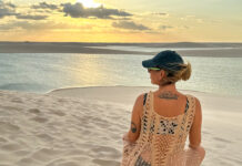 7 erros ao viajar sozinha pela primeira vez (e como evitar cada um) mulher em viagem solo feminina contemplando dunas ao pôr do sol refletindo sobre erros na primeira viagem sozinha